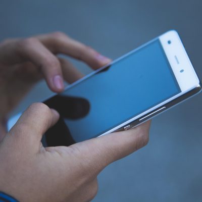 七味网技术维护小满在双屏前检查页面链接状态，屏幕冷光映在眼镜上，体现站点巡检的严谨日常